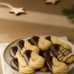 Schokoladenüberzogene Spritzgebäck mit Haselnüssen auf Teller