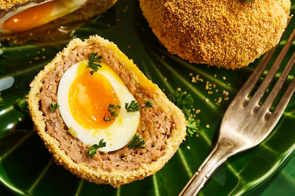 Nahaufnahme eines aufgeschnittenen schottischen Eis aus dem Airfryer mit perfekt wachsweichem Kern und würziger Fleischhülle.