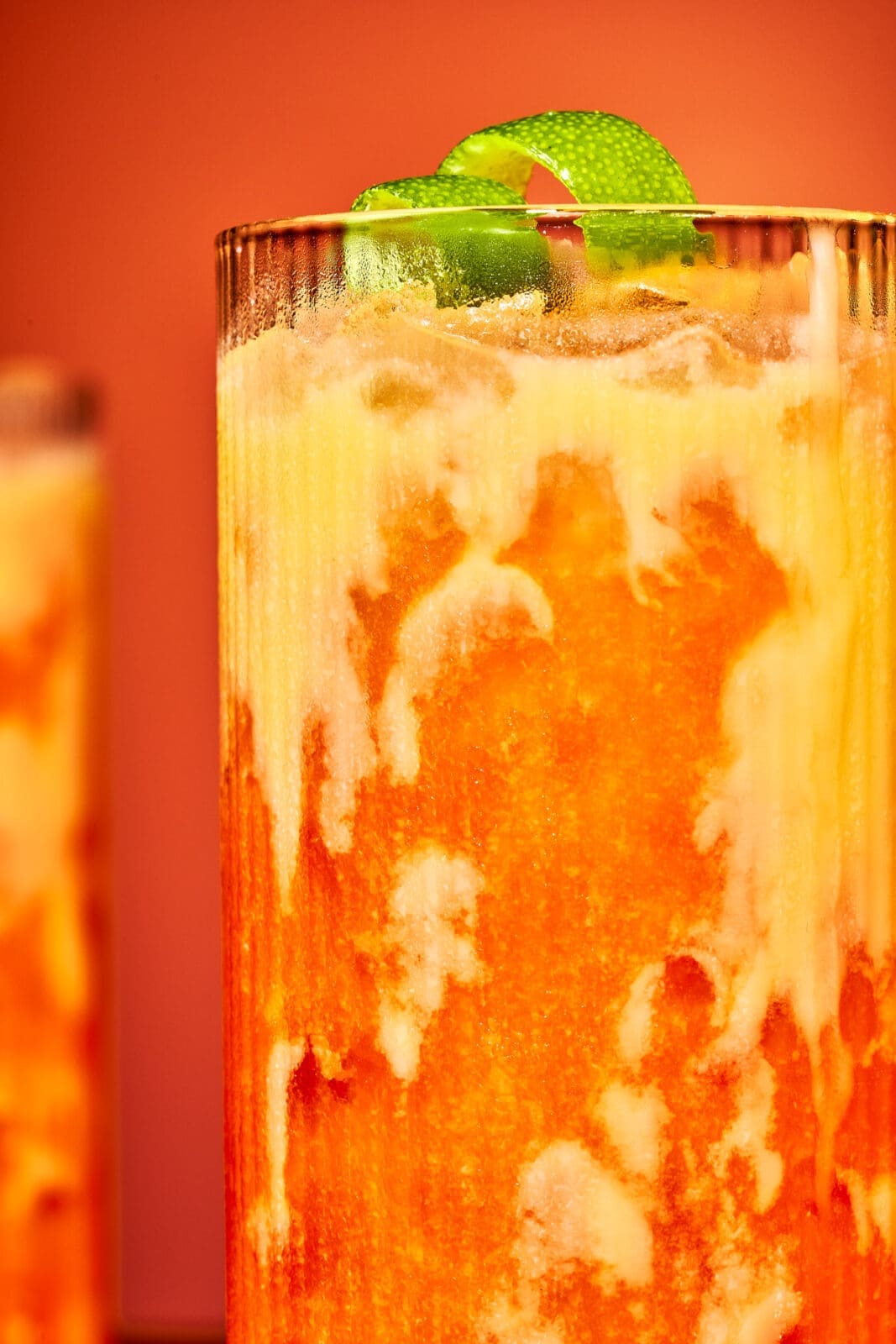 Detailansicht des Marmor-Effekts im Glas, wenn Eierlikör auf den orangefarbenen Karotten-Maracuja-Mix trifft.
