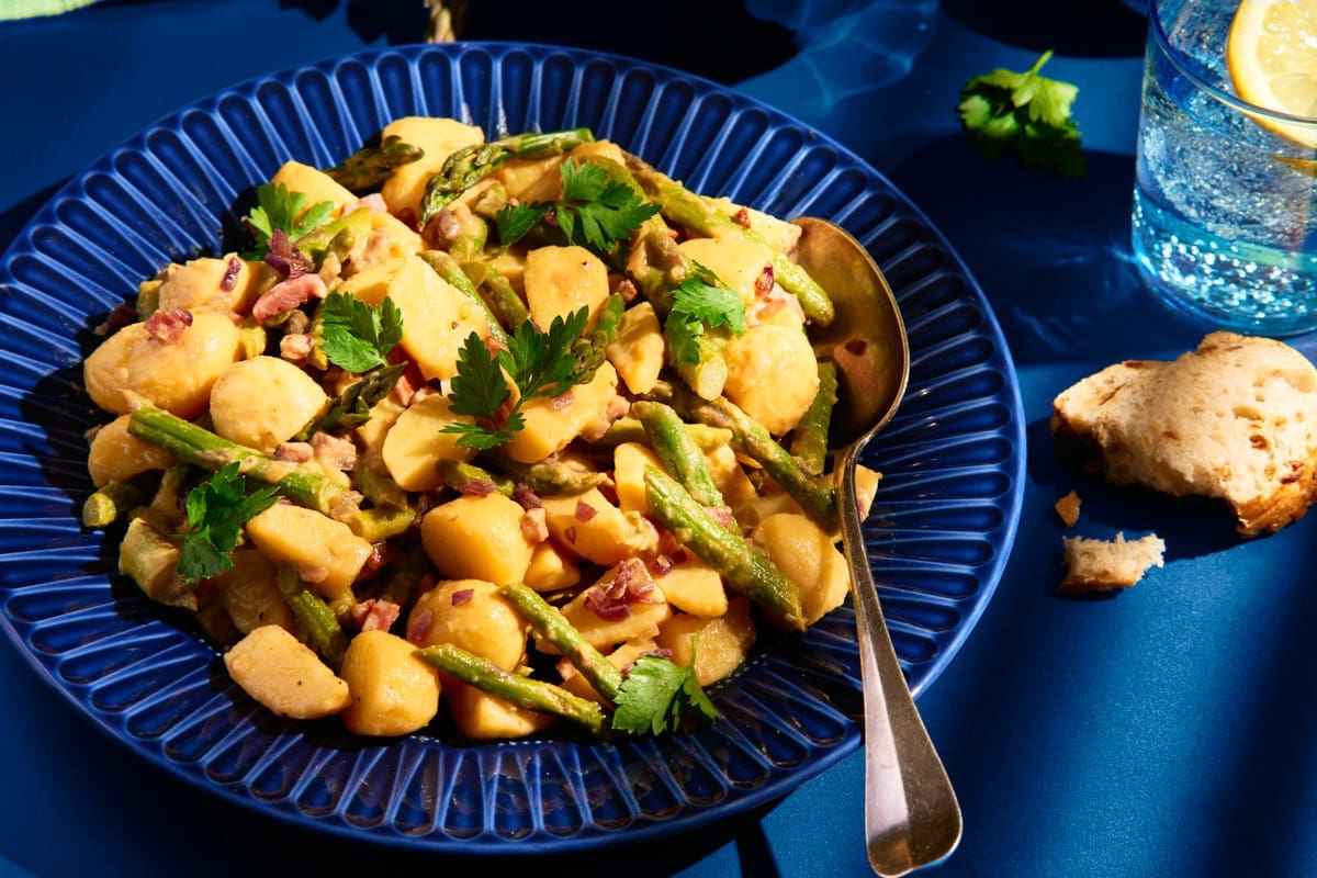 Kartoffelsalat mit grünem Spargel auf blauem Teller