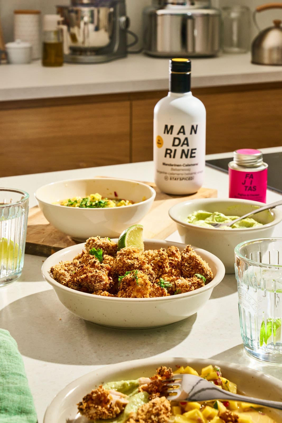 WEB ChickenNuggets Fajita 11 | Chili-Lime Chicken Nuggets aus dem Airfryer. Wenn bei uns Freunde zum Spieleabend oder einfach auf ein Glas Wein vorbeikommen, dann steht immer irgendetwas Leckeres auf einer Platte auf dem Tisch. Für den nächsten Freunde-Abend haben wir dieses Rezept entwickelt und dabei so oft probiert, dass am Ende klar war, dass wir das nicht nur für uns behalten dürfen. Ihr müsst es genauso kennen lernen. Die Kombination aus knusprig paniertem Hähnchen, fruchtig-scharfer Mango-Mandarinen-Salsa und cremigem Avocado-Dip trifft absolut unseren Geschmack.