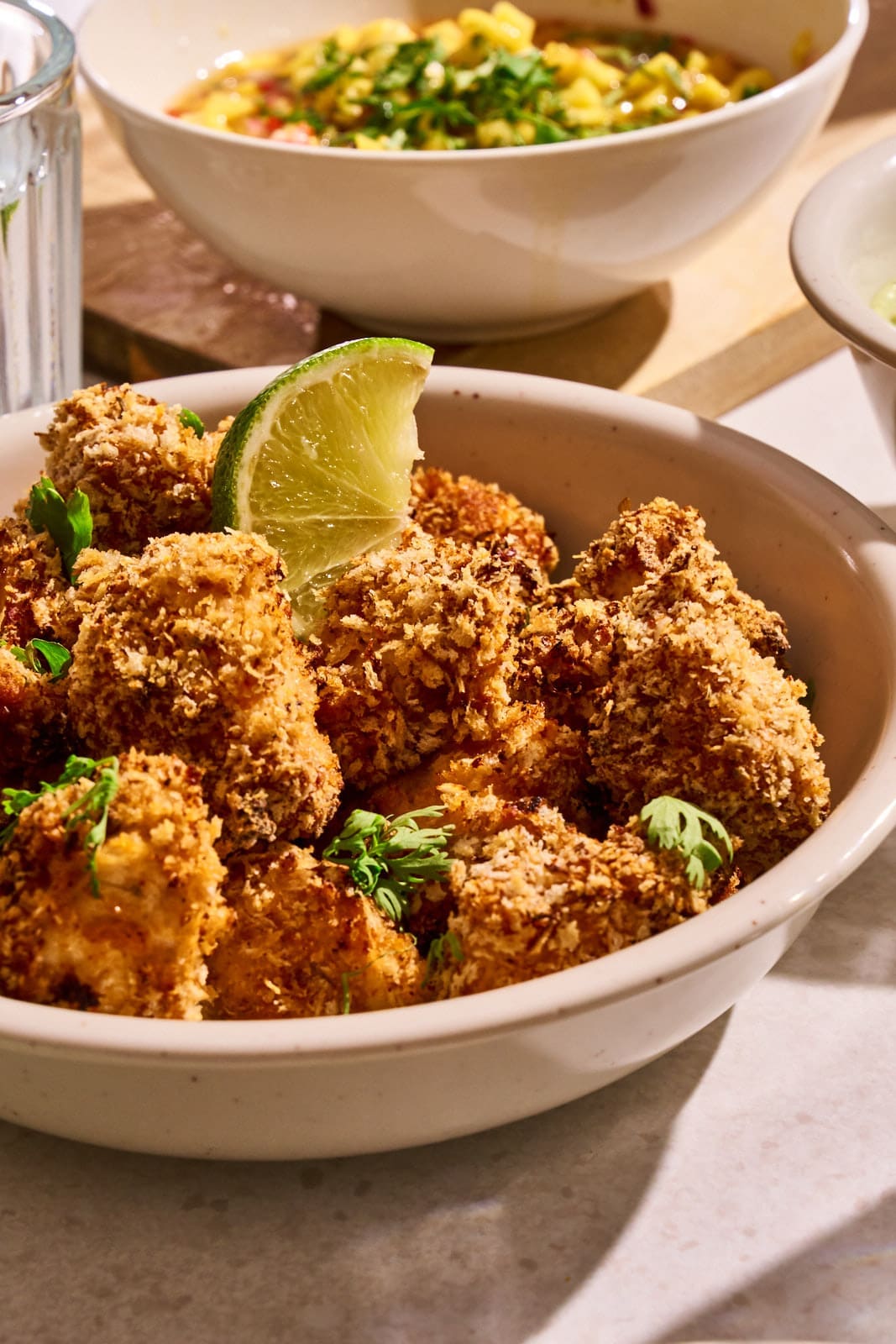 WEB ChickenNuggets Fajita 9 | Chili-Lime Chicken Nuggets aus dem Airfryer. Wenn bei uns Freunde zum Spieleabend oder einfach auf ein Glas Wein vorbeikommen, dann steht immer irgendetwas Leckeres auf einer Platte auf dem Tisch. Für den nächsten Freunde-Abend haben wir dieses Rezept entwickelt und dabei so oft probiert, dass am Ende klar war, dass wir das nicht nur für uns behalten dürfen. Ihr müsst es genauso kennen lernen. Die Kombination aus knusprig paniertem Hähnchen, fruchtig-scharfer Mango-Mandarinen-Salsa und cremigem Avocado-Dip trifft absolut unseren Geschmack.