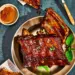 Saftige Spareribs auf dem Teller. Gesamtansicht mit Trockenrub und Glasur